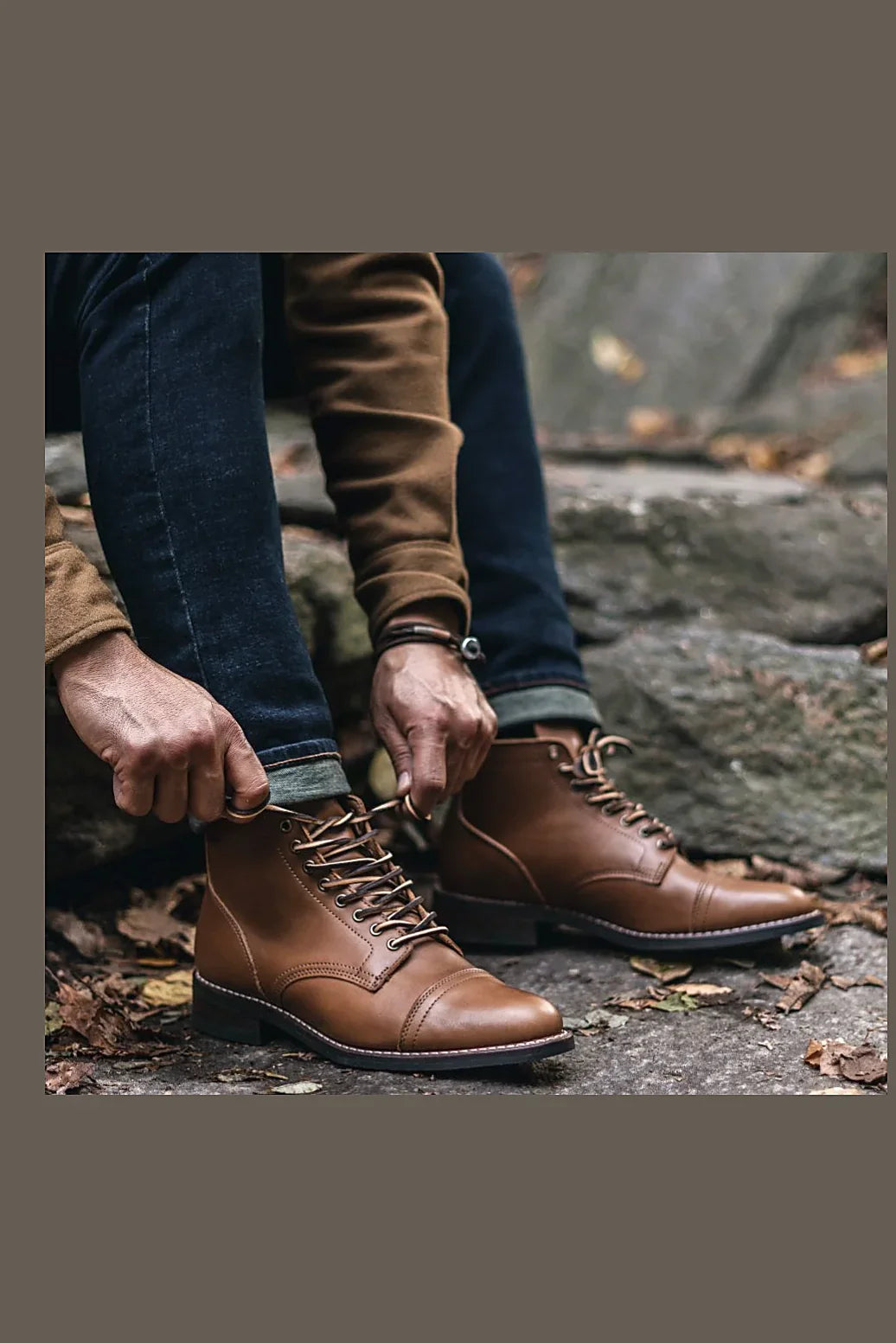 Hands lacing a leather boot on rock
