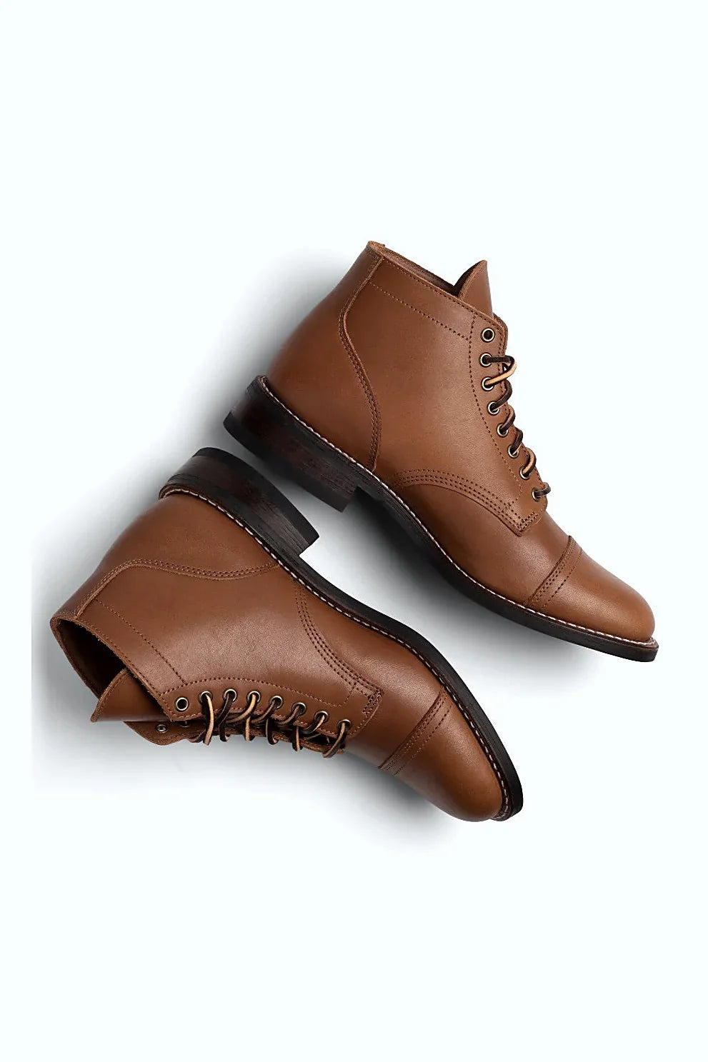 A pair of leather boots angled to show the welt stitching along the sole